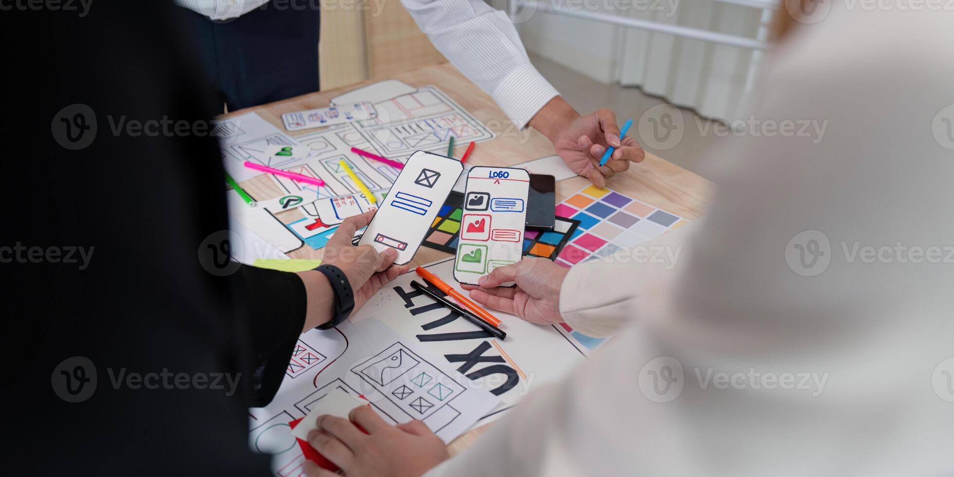 Dynamic UX UI team reviewing mobile app wireframes and sketches during a collaborative design session photo