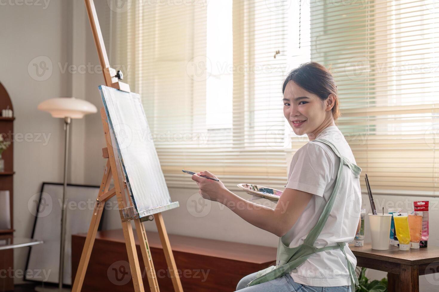 Smiling young artist preparing to paint in a cozy studio, expressing creativity and joy photo