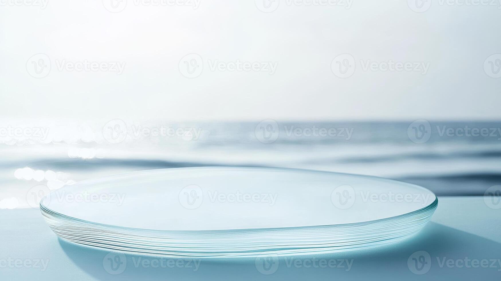 Clear glass plate resting on a surface with ocean waves gently lapping in the background under soft sunlight photo