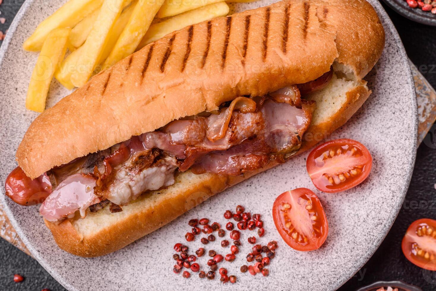 Delicious juicy hot dog with sausage, bacon, sauce, salt and spices y photo