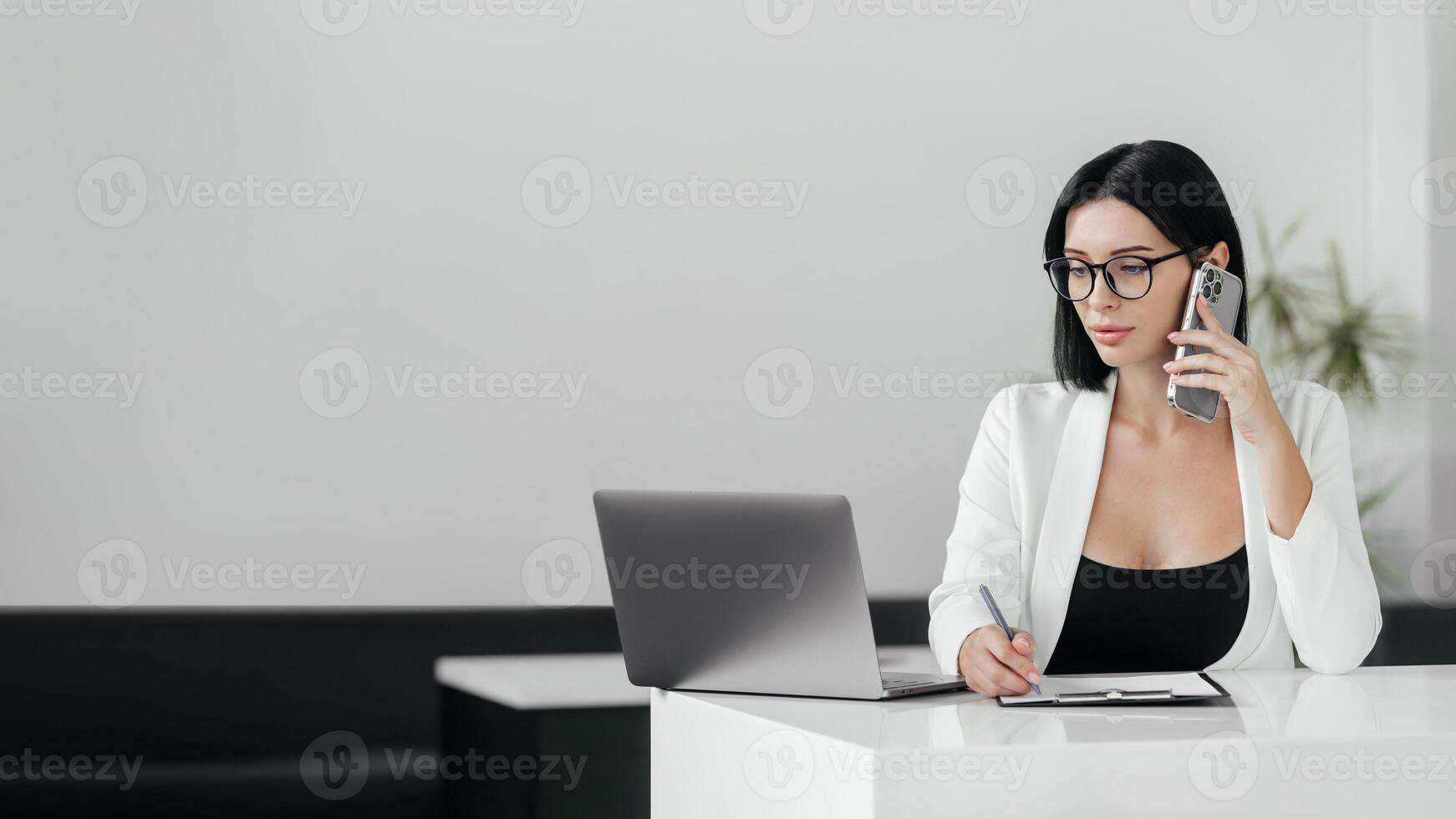 Confident hispanic businesswoman in glasses working on laptop at her workplace at modern office against white background. 30s middle female using computer technology app for work online. Copy space photo