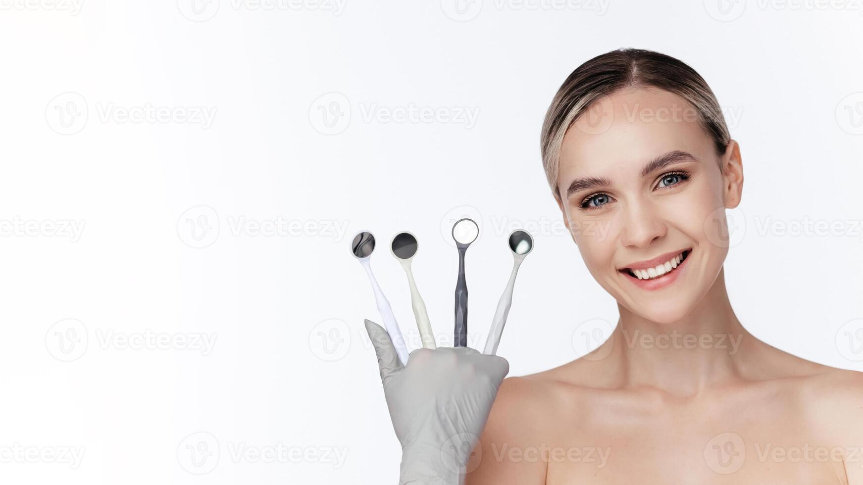 Caucasian smiling female holding dental mirrors against white background. Teeth care, dental treatment, tooth extraction, implant concept. Dental clinic special offer. Free copy space, advertising photo