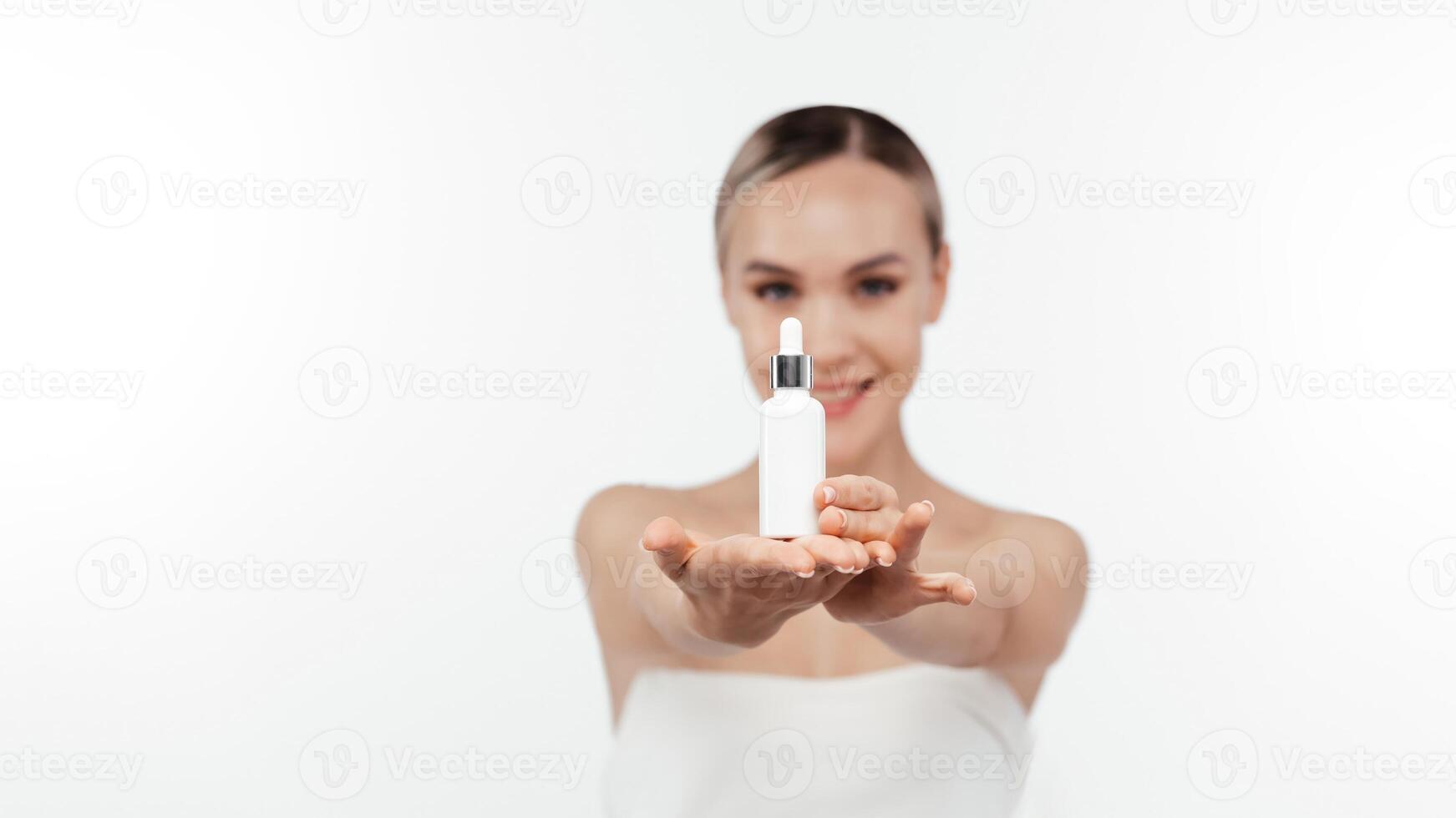 Female hand holding a tube of cream, serum bottle. Woman hand showing cosmetic product, branding mockup. Skincare and face care routine. Mock up, template, white background, cosmetology, copy space photo