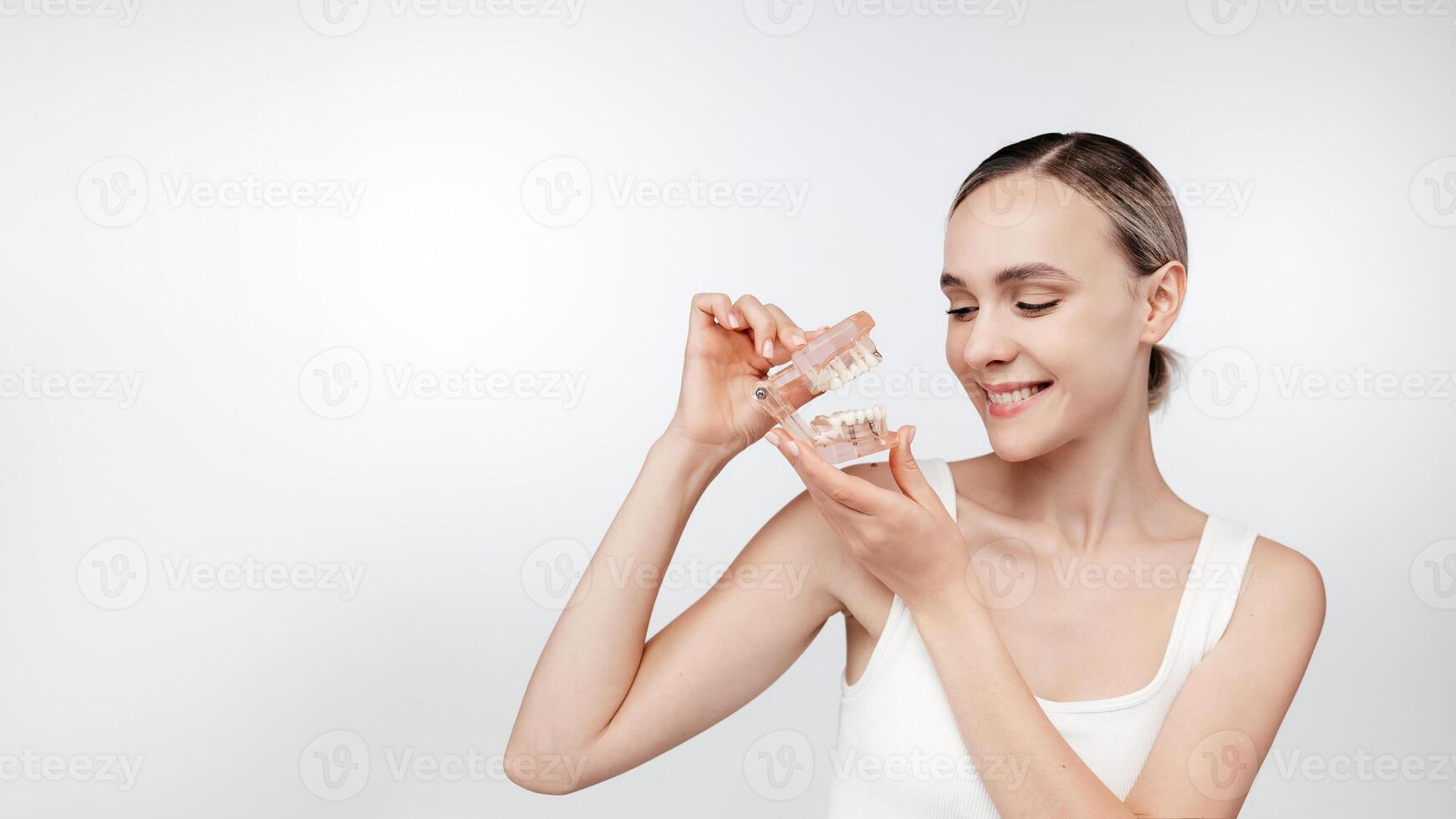 Dentist hold teeth model used for dental care consultations, dental clinics and oral treatments. White healthy perfect teeth plastic model. Implants, educational and explanatory materials. Copy space photo
