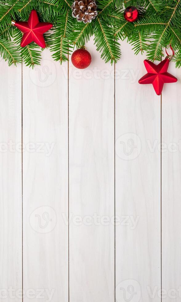 Top view flat lay of a white table with Christmas tree decorations, wooden ornaments, and a pinecone, featuring central empty space for promo text photo