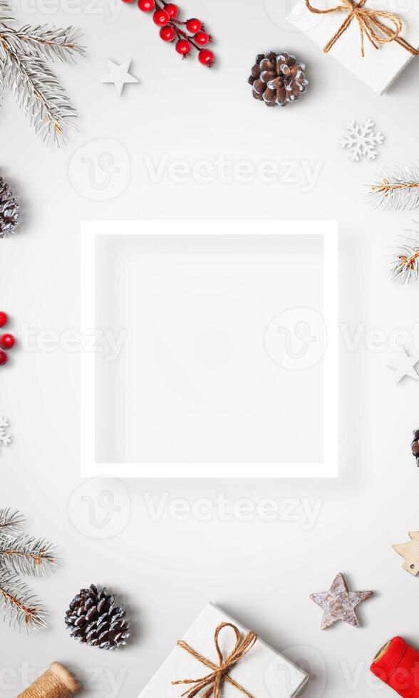 White table with Christmas decorations, top view, flat lay, featuring a square white frame for text or logo, resembling a beautiful holiday greeting card photo