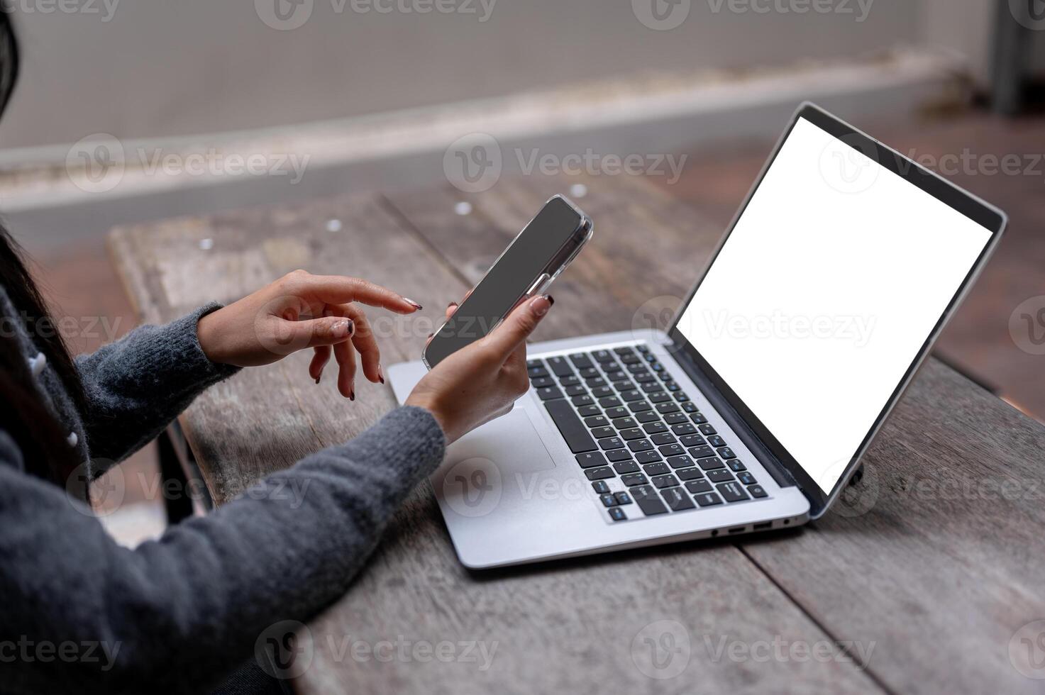 A close-up of a woman using her smartphone, texting to someone while working remotely from outdoors. photo