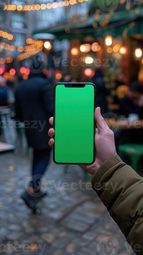 Mockup image of a smartphone with green screen in a man's hand photo