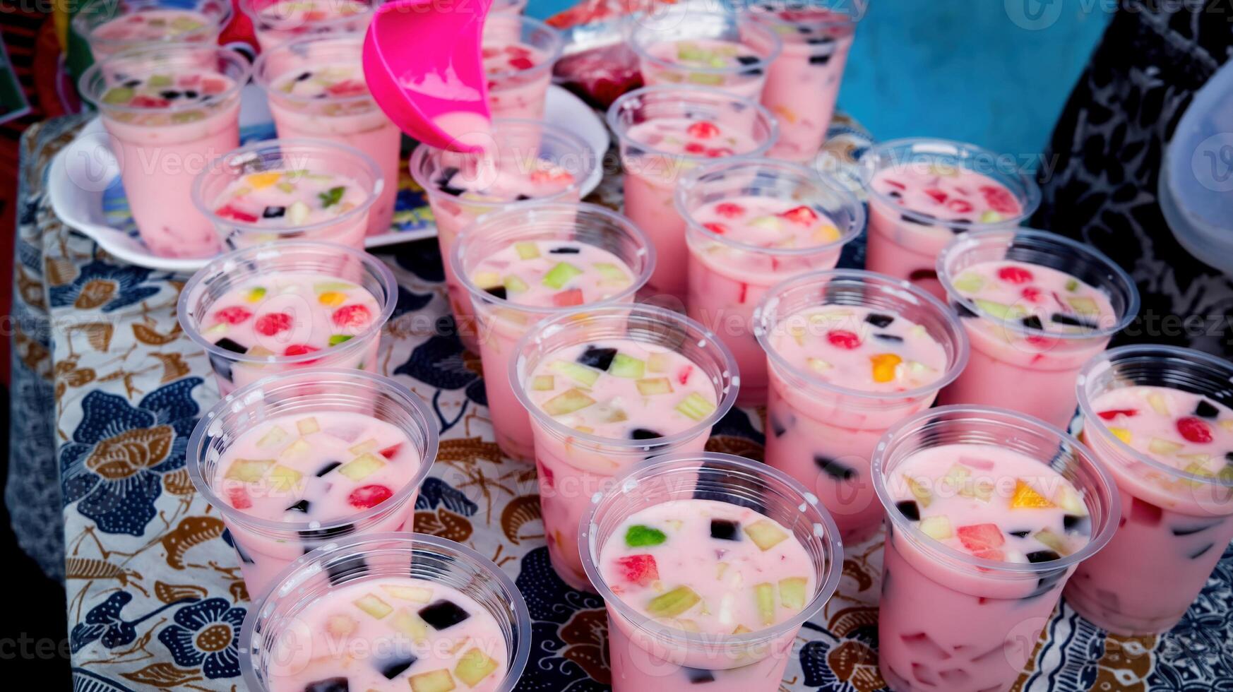 Fruit ice in plastic cups ready to be distributed at school activities photo