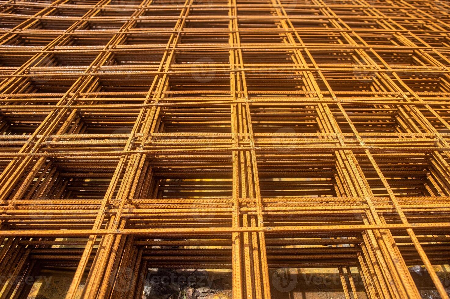 Rusty rebar grid used in construction for reinforcing concrete structures, showcasing the intricate pattern and texture of the steel bars photo