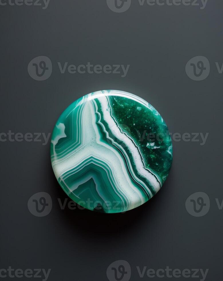 A close up of a green and white agate on a black background photo