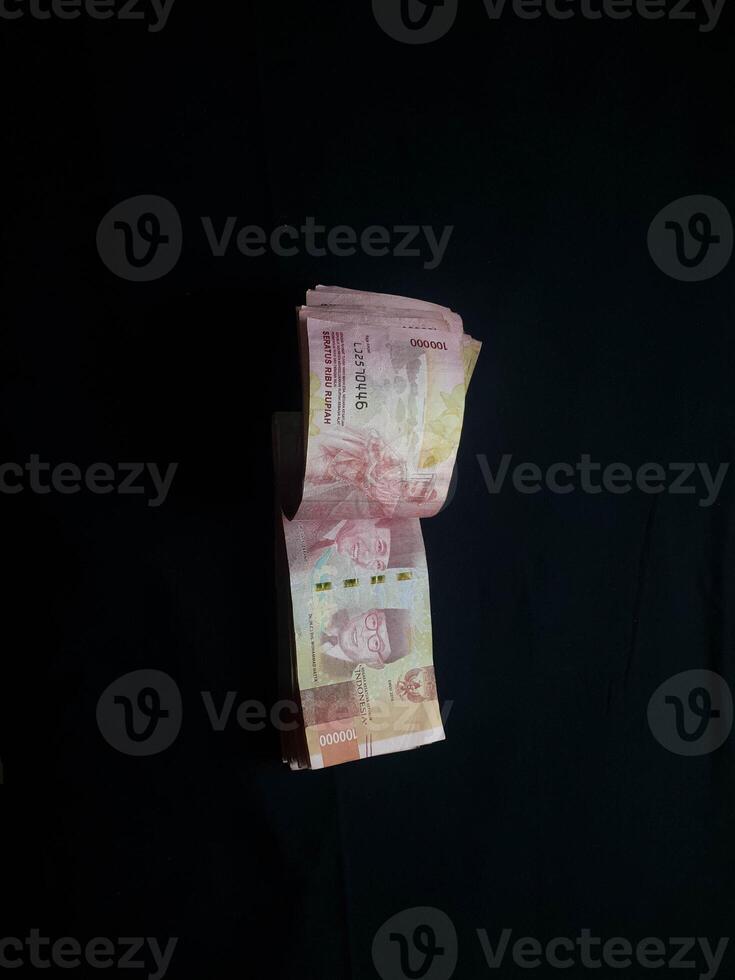 Indonesian Rupiah currency notes stacked on a dark surface studio shot photo