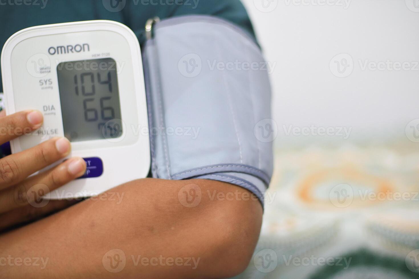 Lampung Selatan, september 13, 2024, Person using digital blood pressure monitor for health check photo
