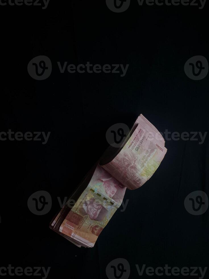 A stack of Indonesian Rupiah banknotes on a dark background showcasing currency photo