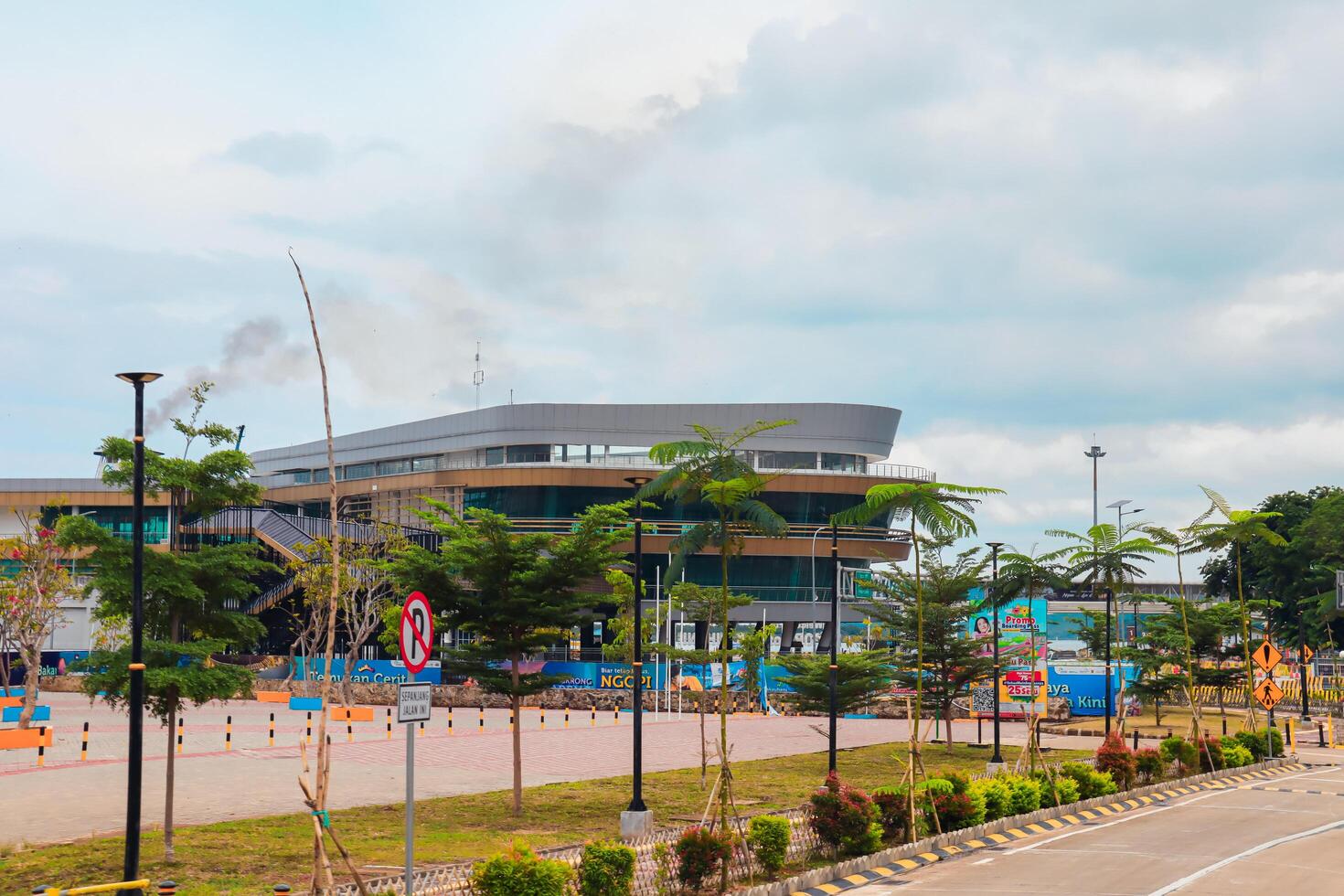 Bakauheni, January 17, 2025, Modern building with palm trees on a cloudy day photo