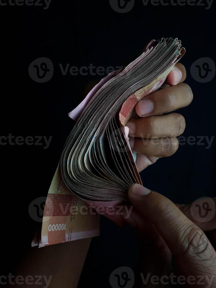 Indonesian Rupiah bills arranged on a dark surface showing 100000 denominations photo