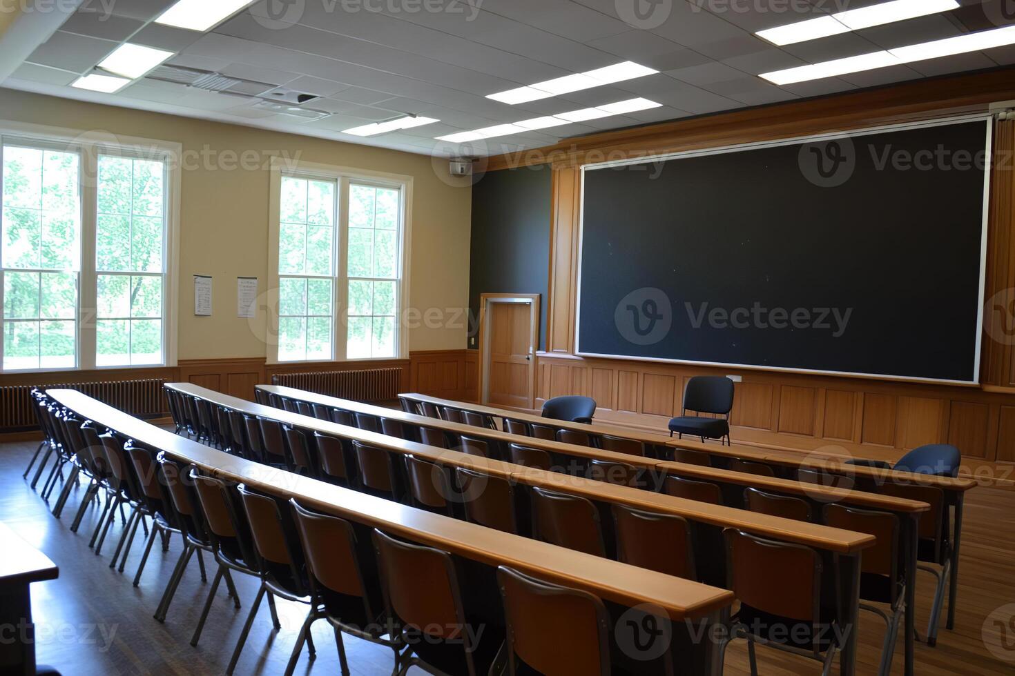 Classroom with rows of desks and large windows showcasing natural light photo