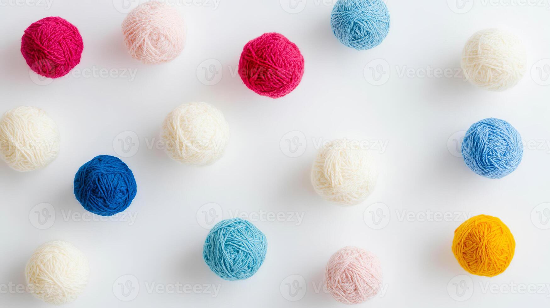 Colorful balls of wool arranged on a white background for crafting and creative projects photo