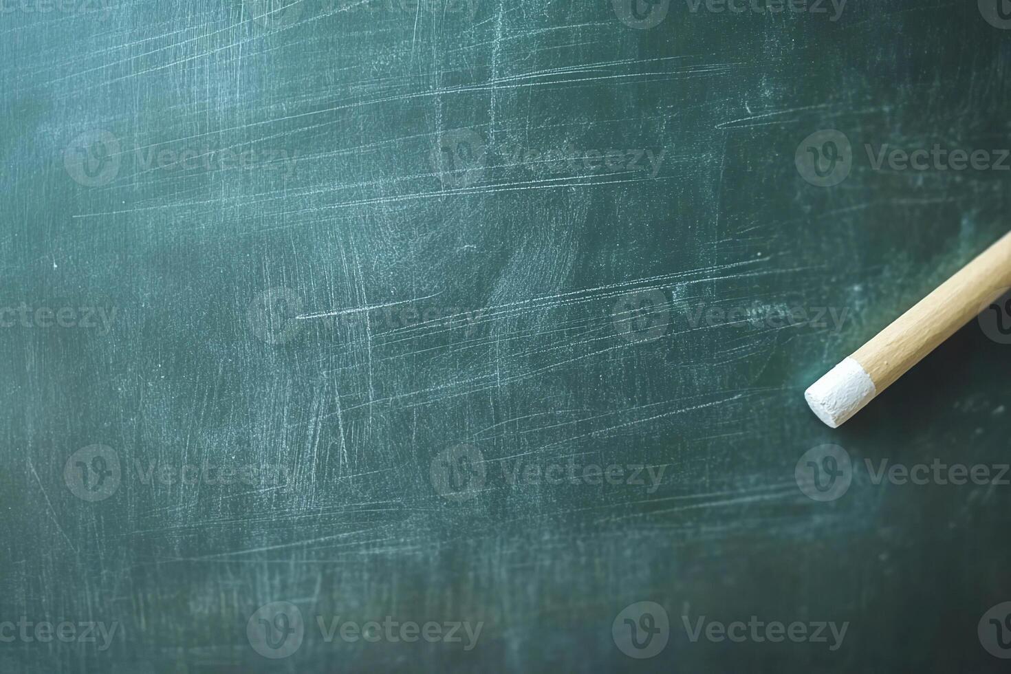Close-up of a clean chalkboard with a piece of chalk resting on its surface in a classroom setting photo