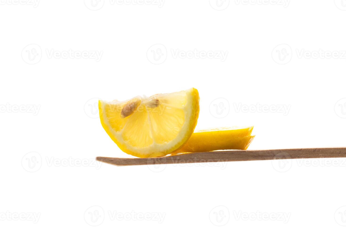 Tea additives. slice of fresh juicy lemon on wooden spatula isolated on white background photo