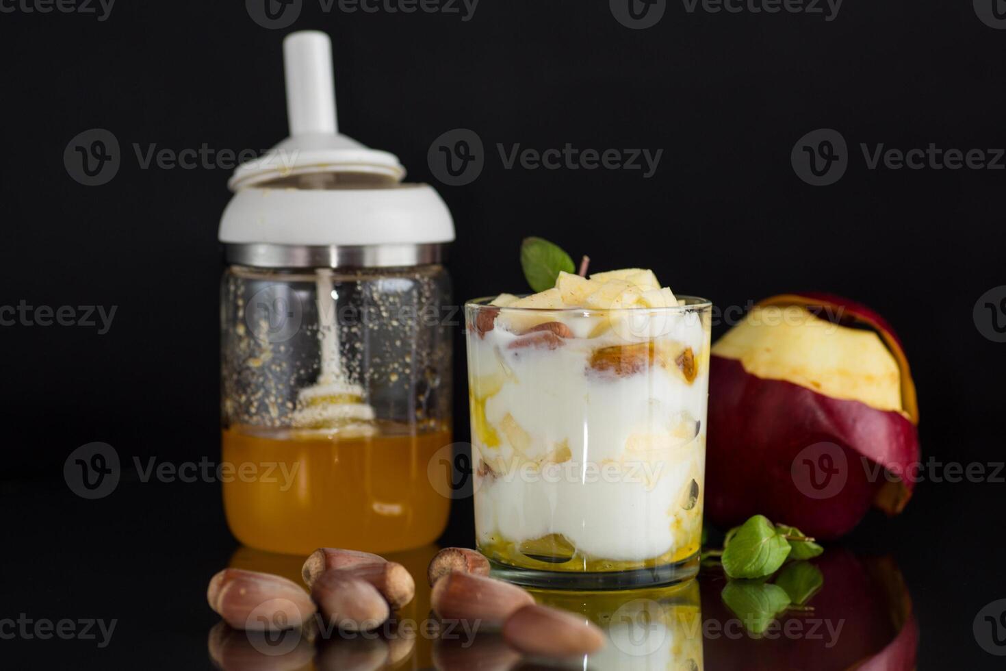 A graceful stroke. sweet homemade yogurt in a glass with apples, nuts and honey photo