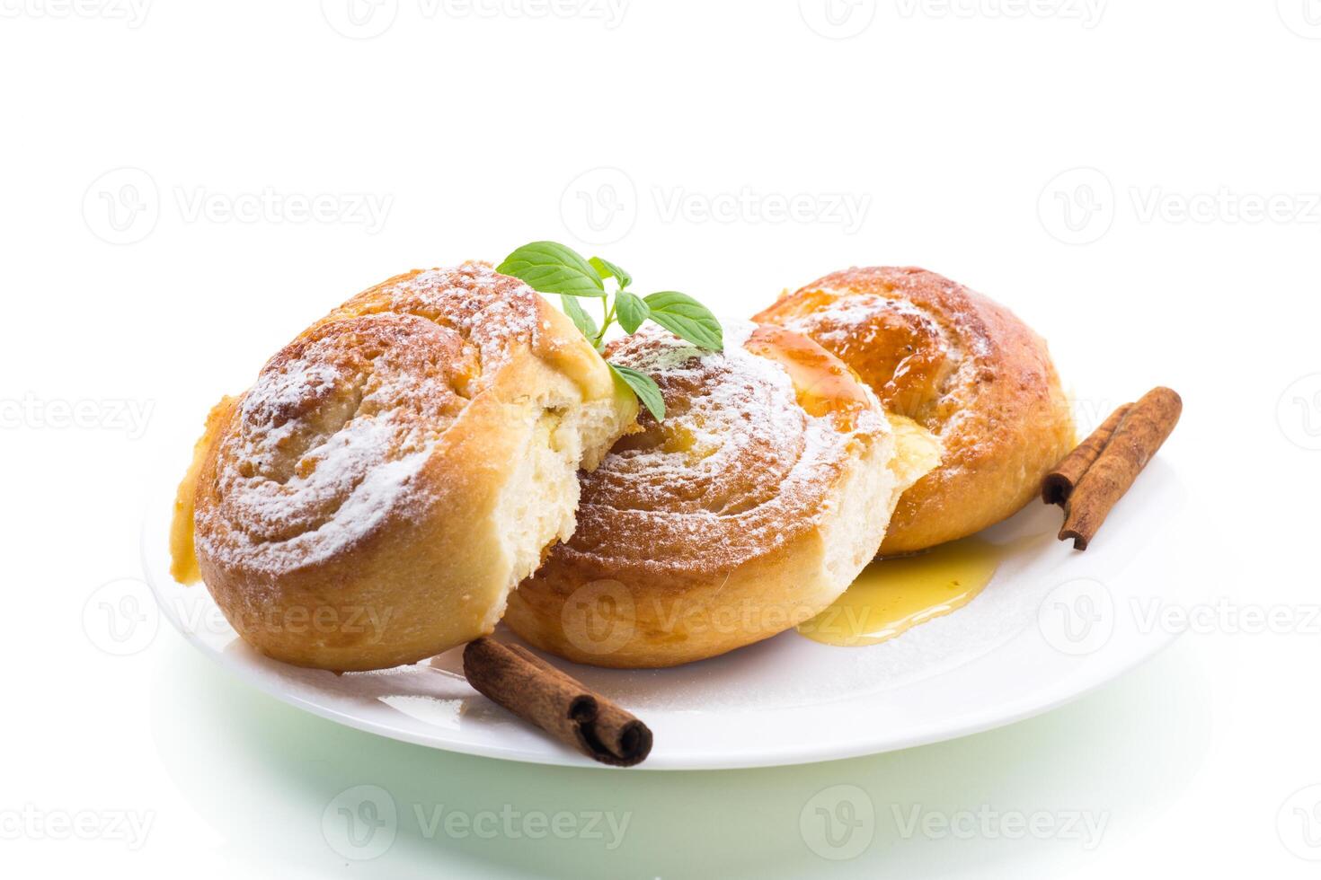 Sweet pastries. Sweet buns with cottage cheese filling and honey in a plate isolated on a white background photo