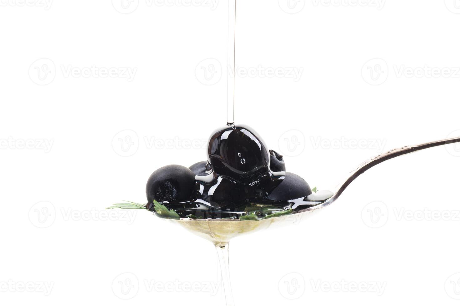black olives in a spoon isolated on a white background photo