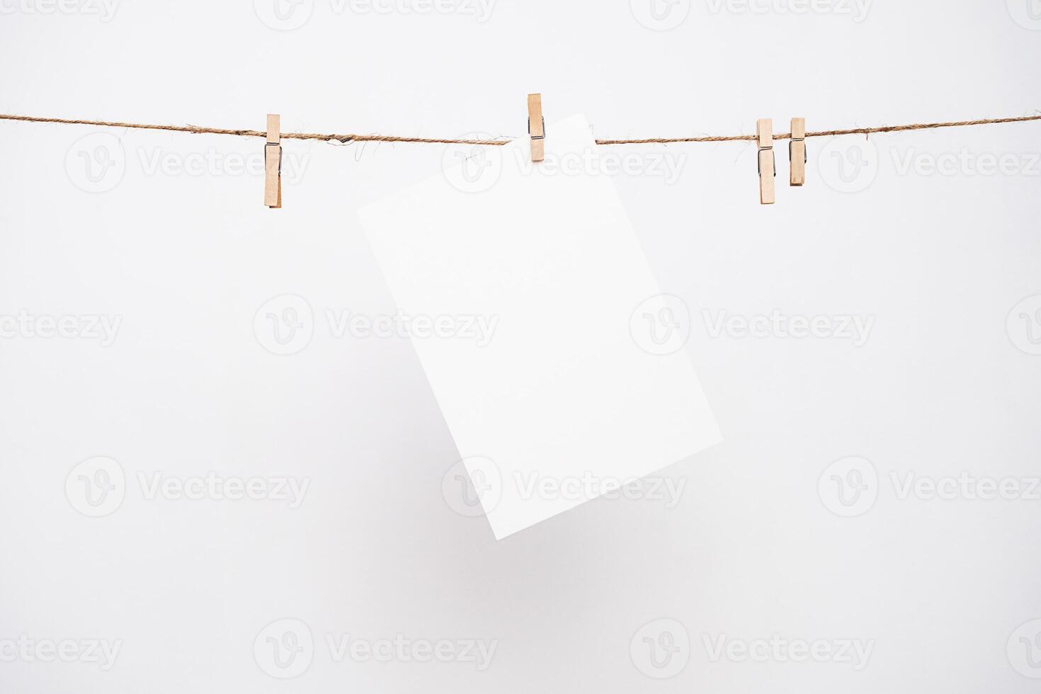 Blank white paper with copy space hanging on a rope. photo