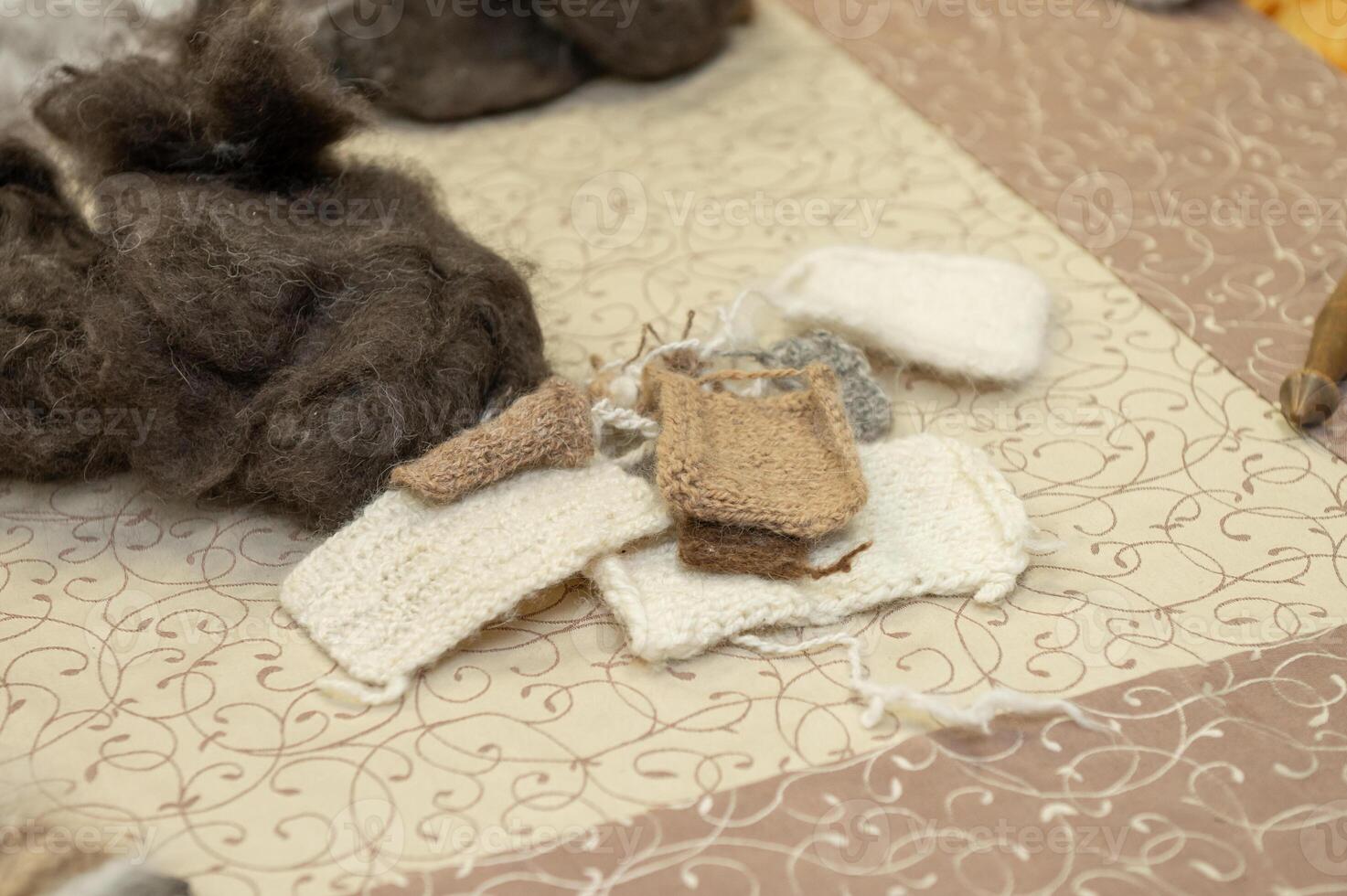 Wool and hand-knitted fabric samples on a patterned surface photo
