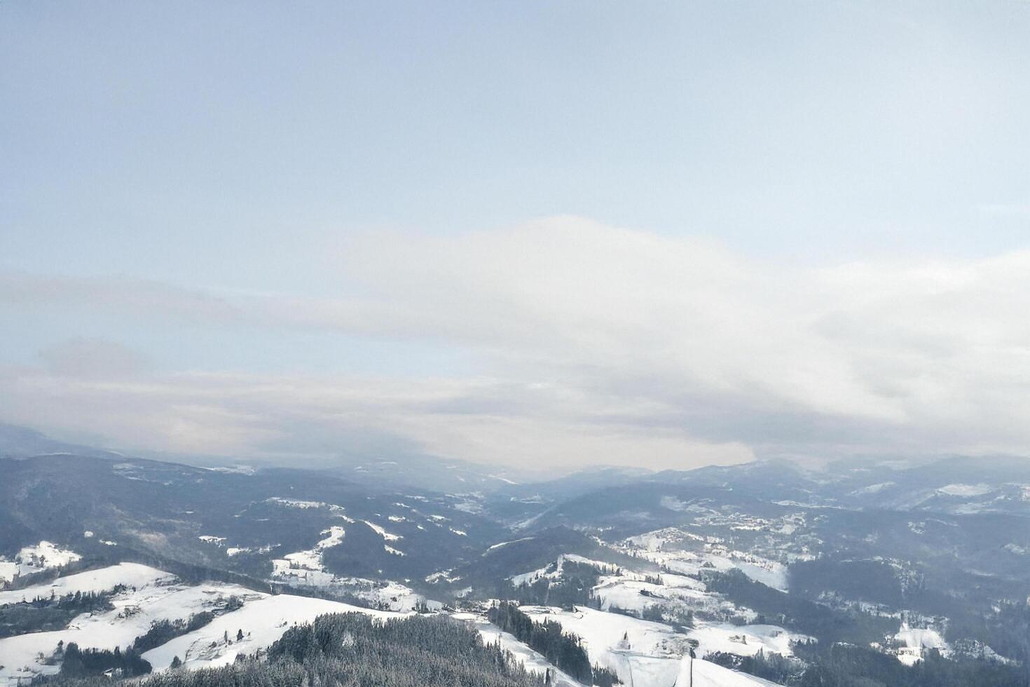Aerial winter mountain valley view, snow-covered landscape, clear sky photo