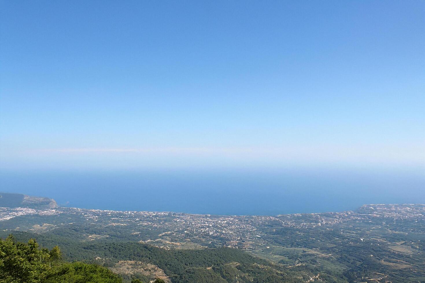 Coastal vista mountaintop view, clear sky, distant city photo