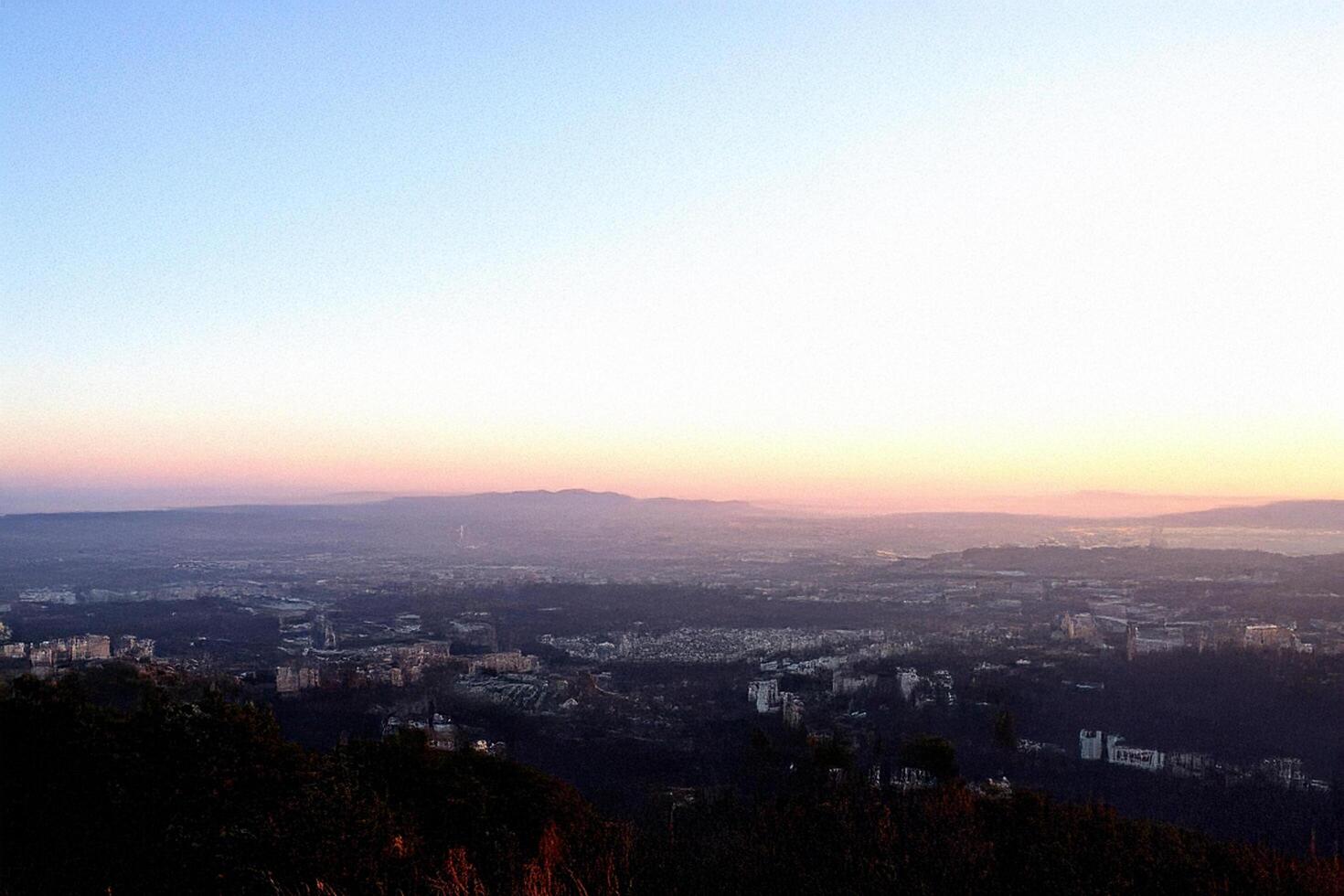 Sunset cityscape panorama, hilltop view, hazy horizon, travel postcard photo