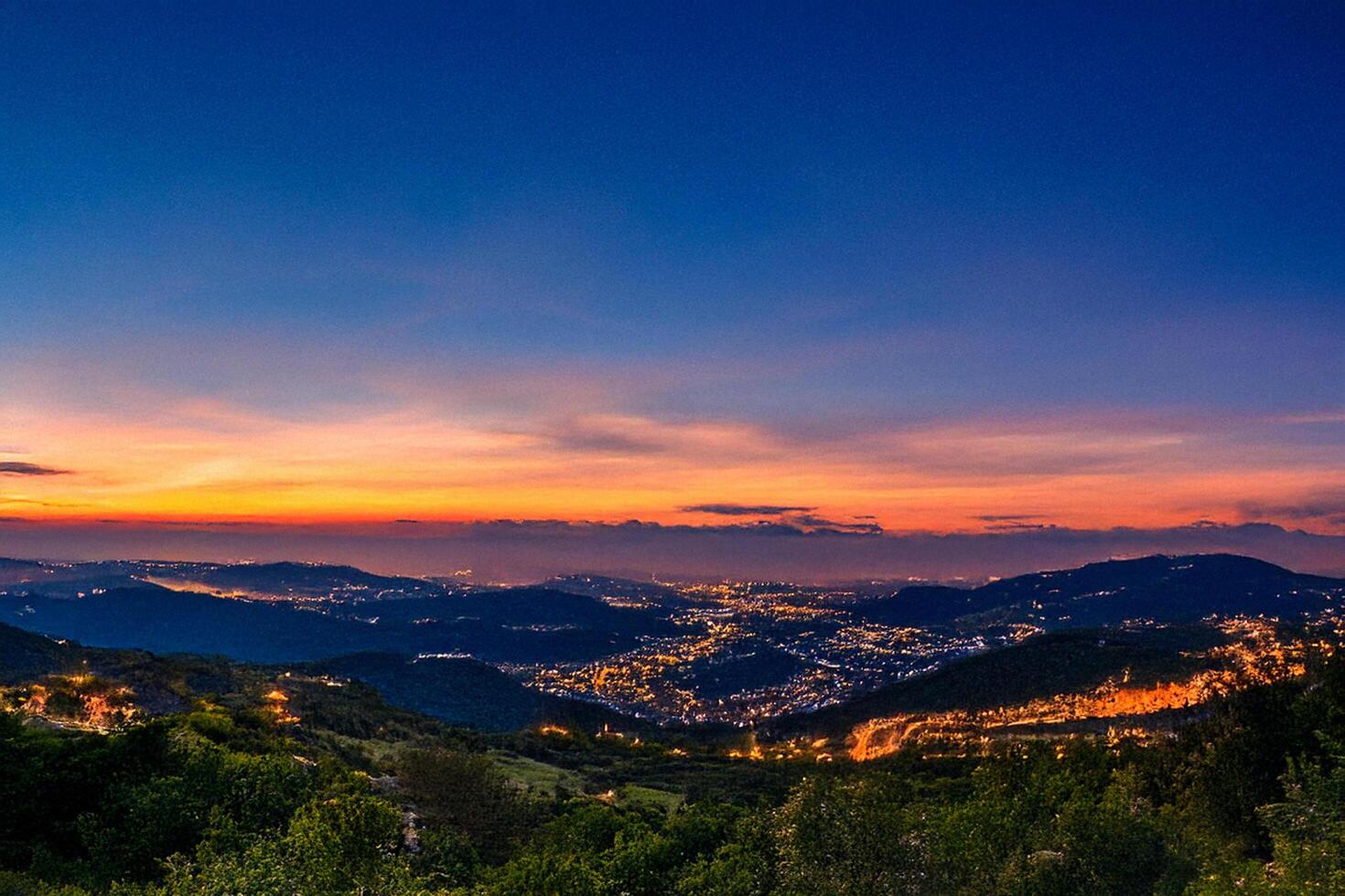 A view of the city at sunset from a hilltop photo