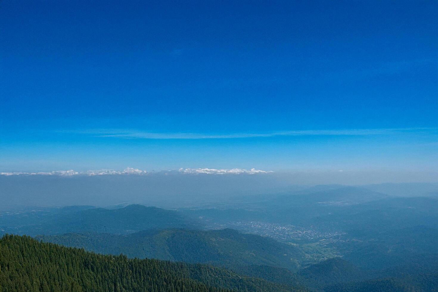 Mountaintop panoramic view distant hazy valley, clear sky photo
