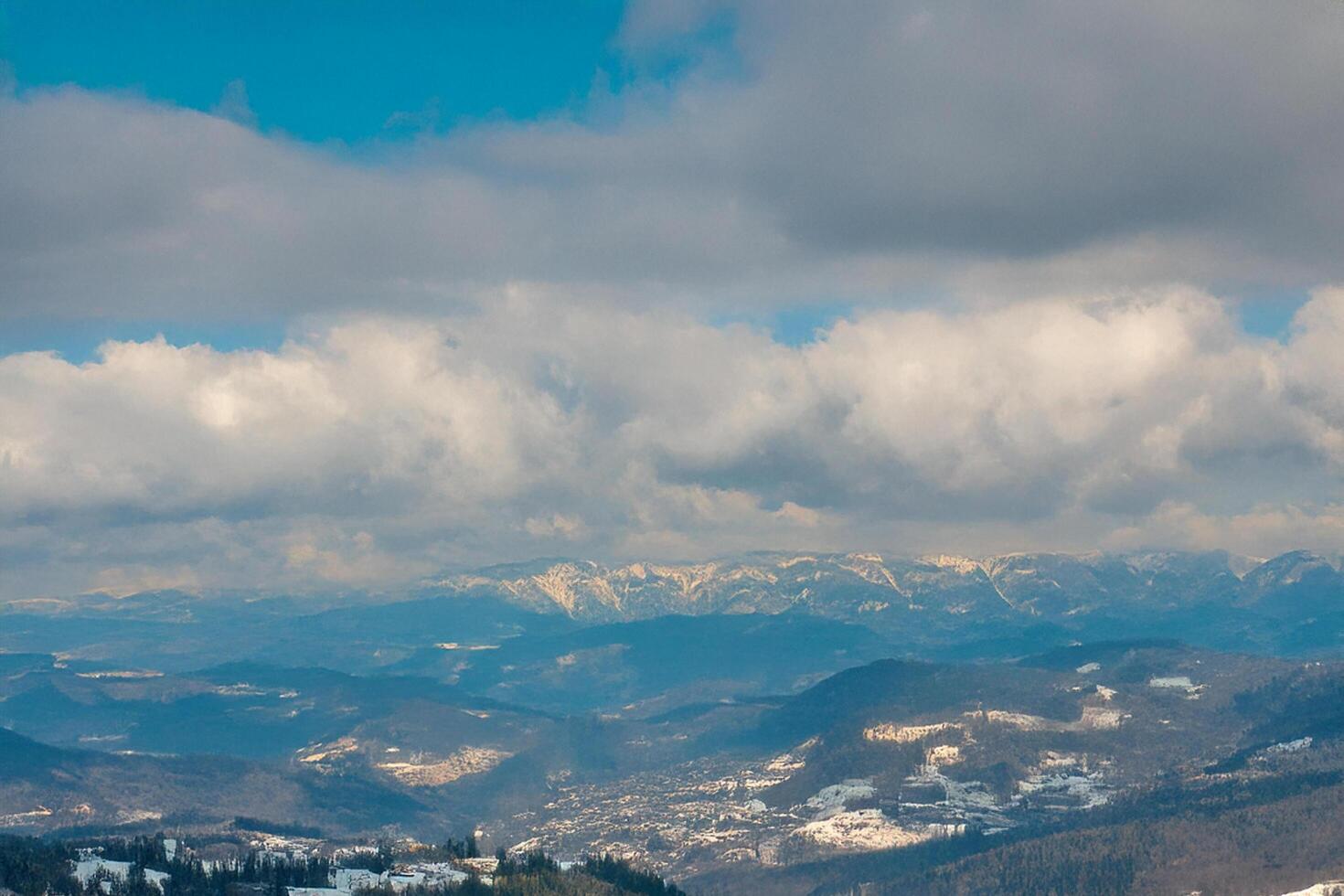 Snowy mountain range aerial view, winter landscape, cloudy sky, travel brochure photo