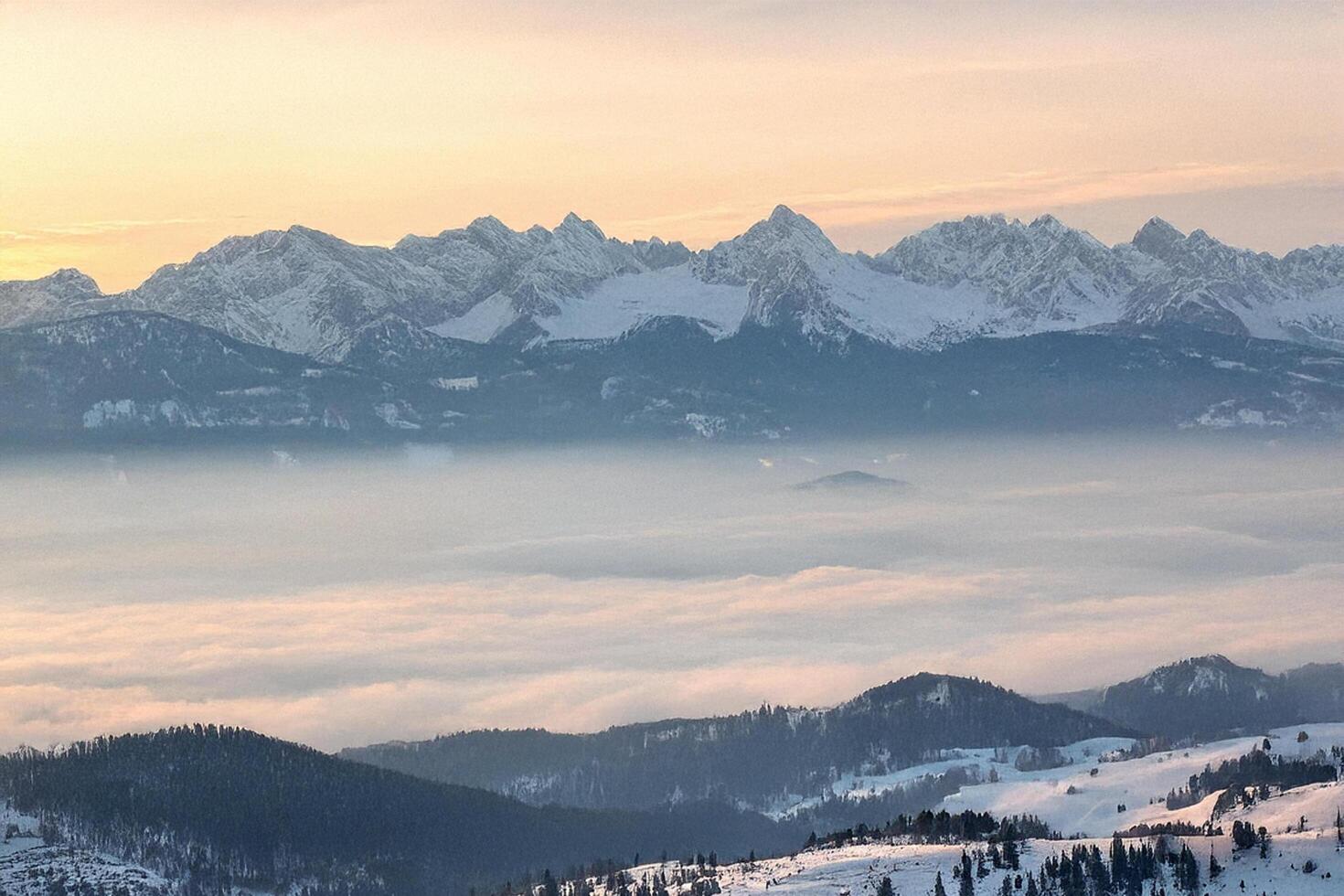 Snowy mountain range sunrise, valley fog, winter landscape photo