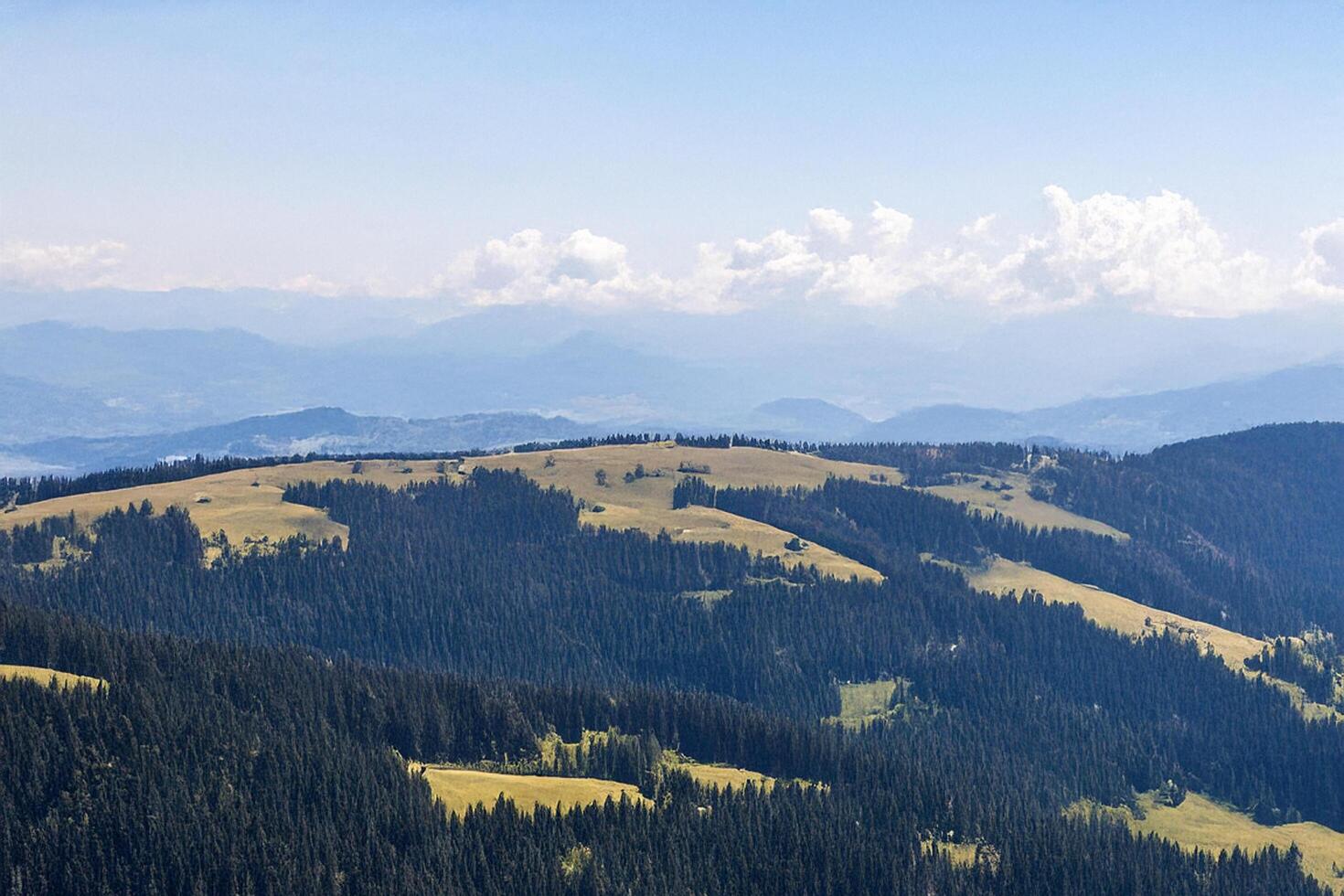 Mountaintop panorama rolling hills, forests, distant peaks photo