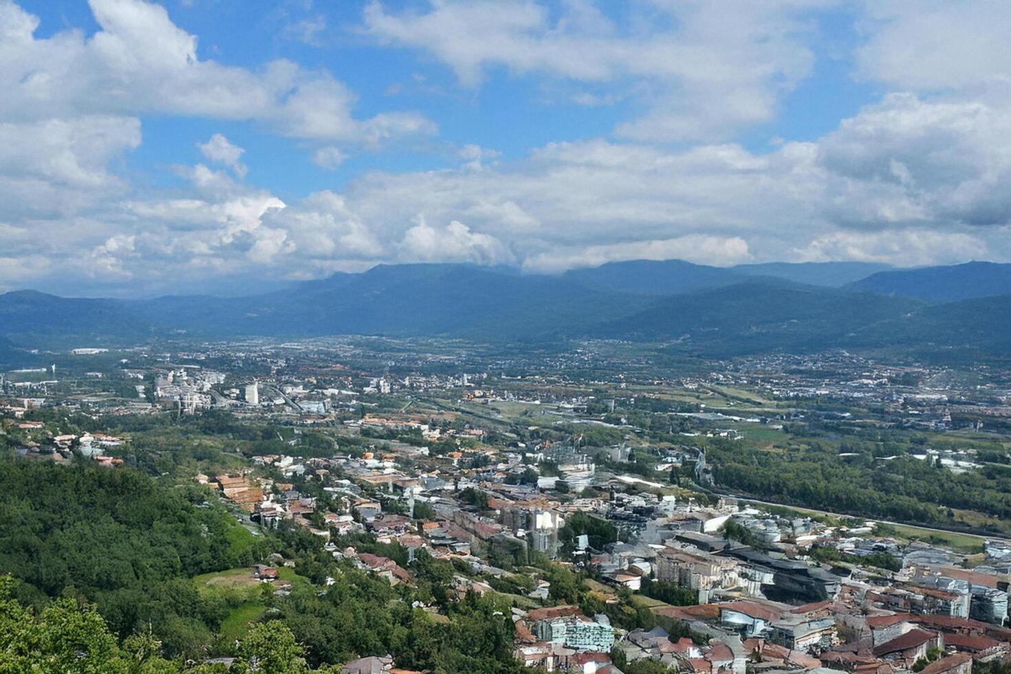 Panoramic city view, mountains background, summer day photo