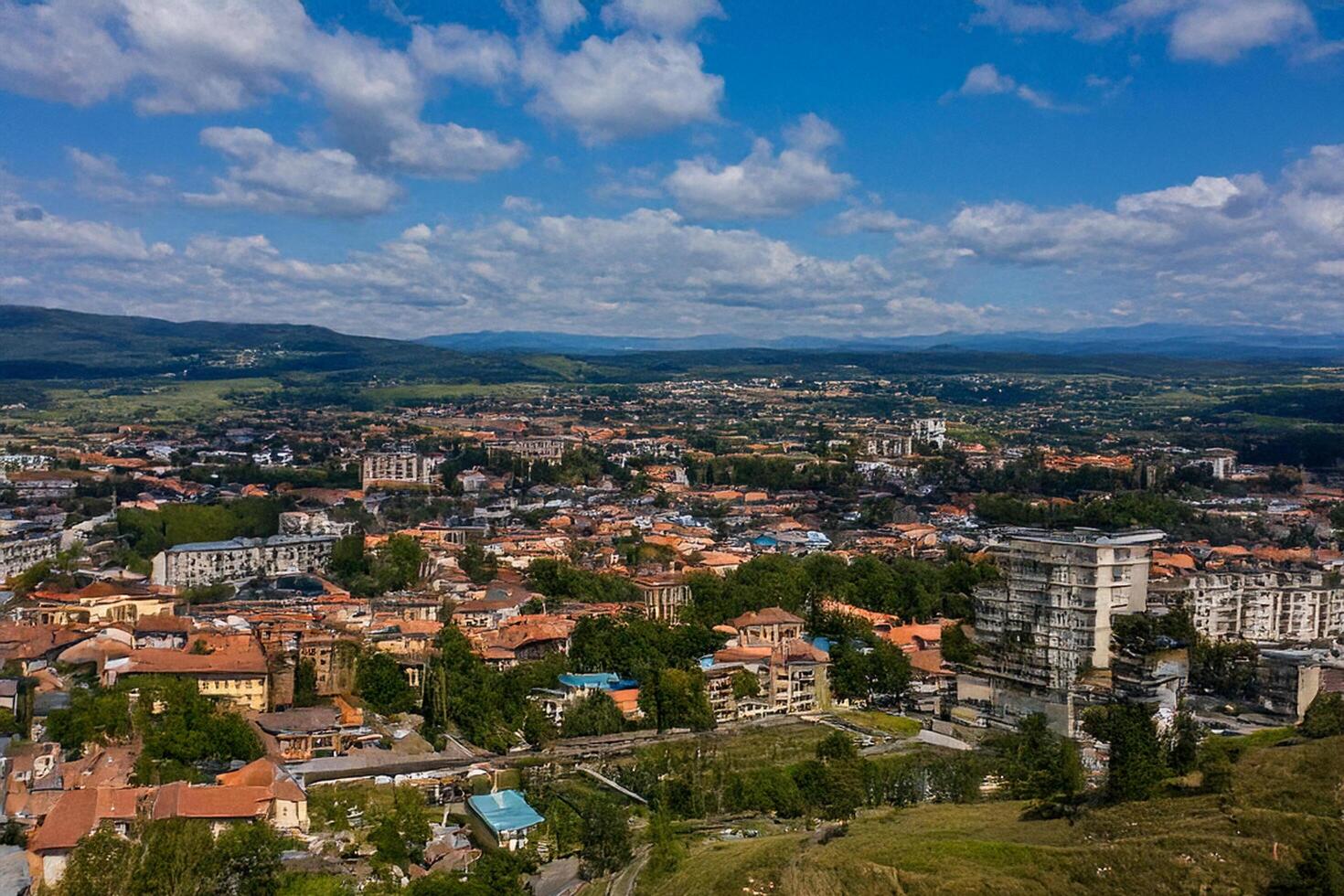 Aerial view city landscape, mountains background, summer day photo