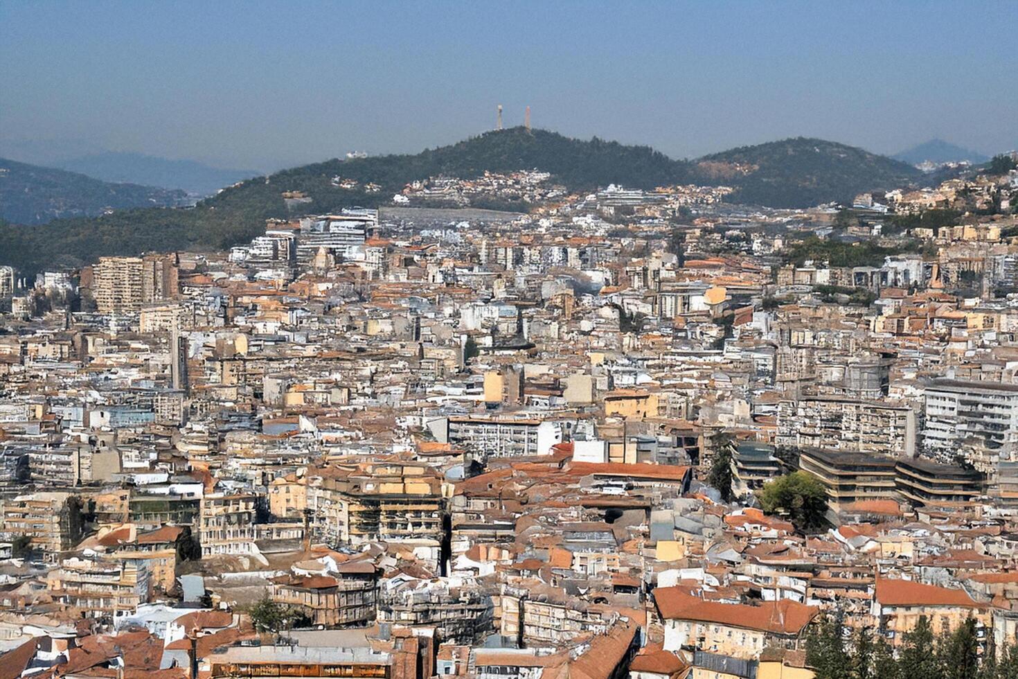 Hilltop Cityscape Panoramic view, urban sprawl, mountain background, travel brochure photo