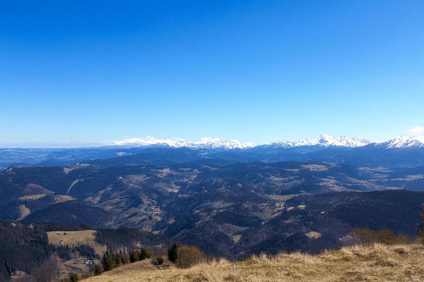 Mountain panorama, clear sky, valley view, distant snow-capped peaks, travel poster photo