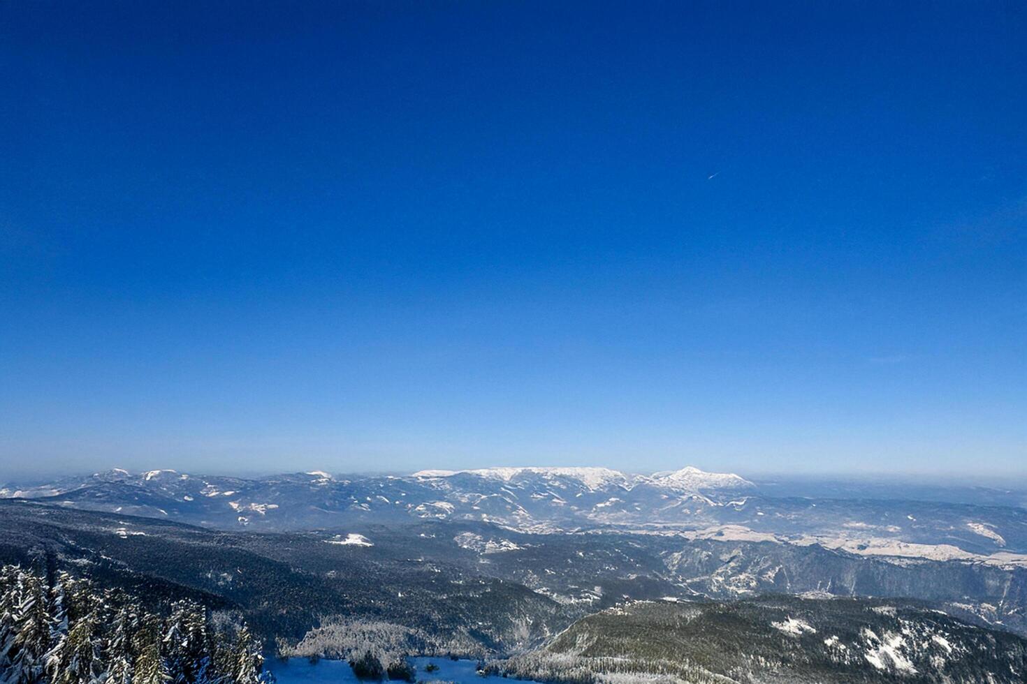Snowy mountain range winter landscape, clear sky, aerial view photo
