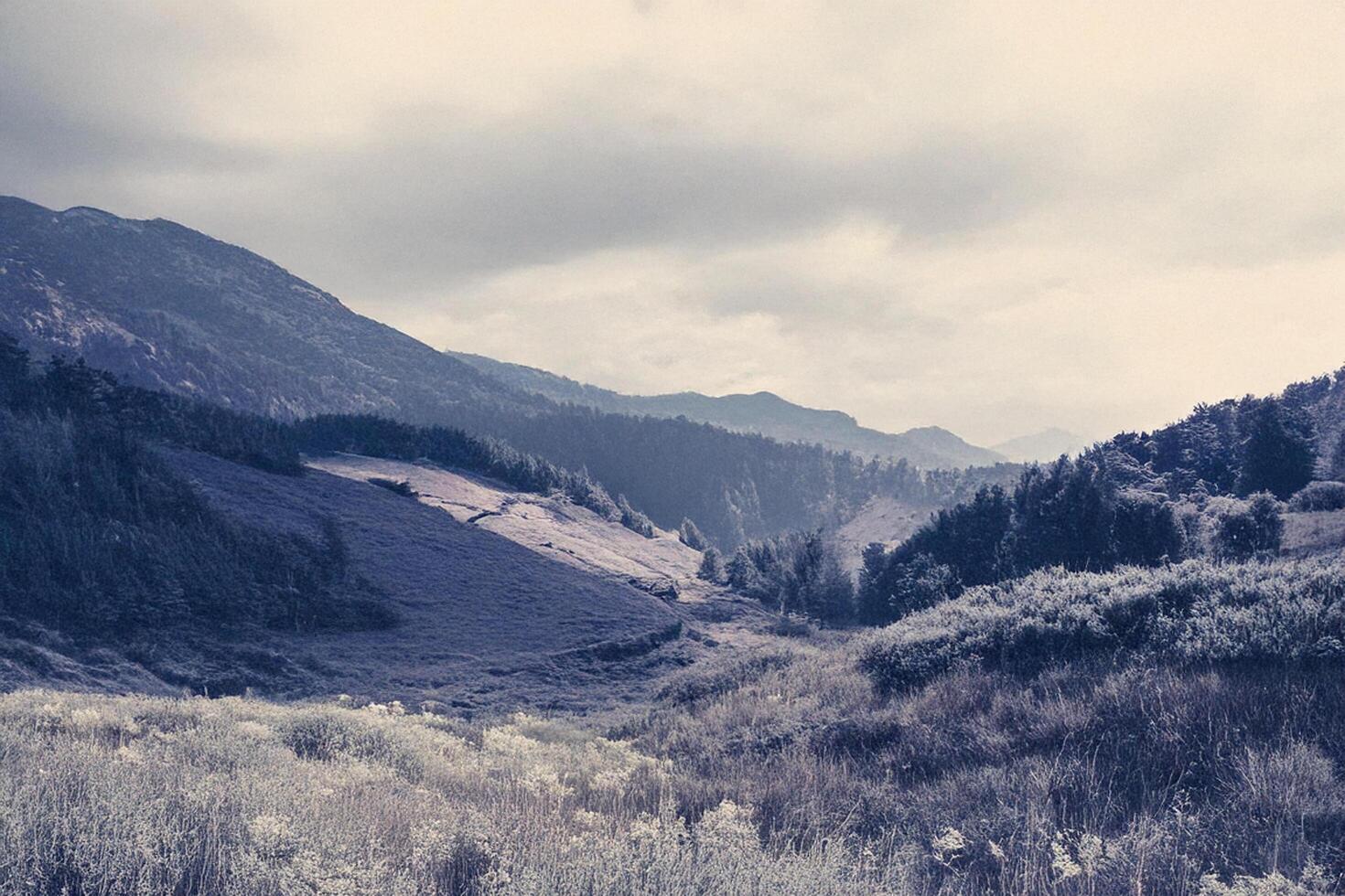 Mountain valley landscape, misty sky, infrared photography, travel poster photo