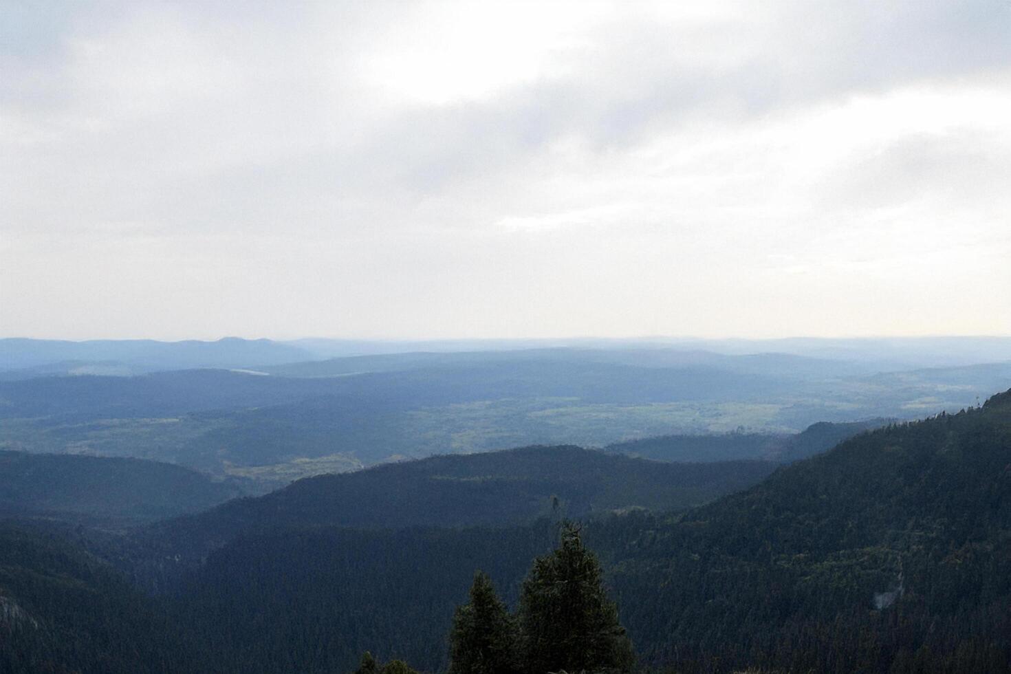 Mountaintop panorama, hazy sky, distant hills, travel postcard photo