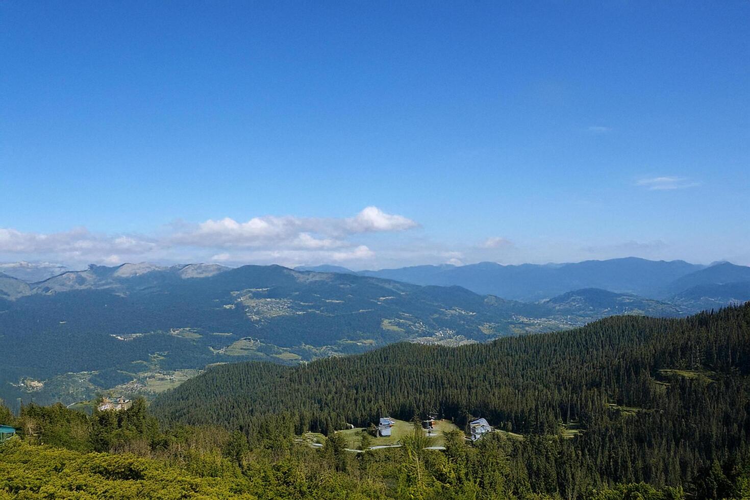 Mountaintop view valley, forest, clear sky, distant buildings, travel photo