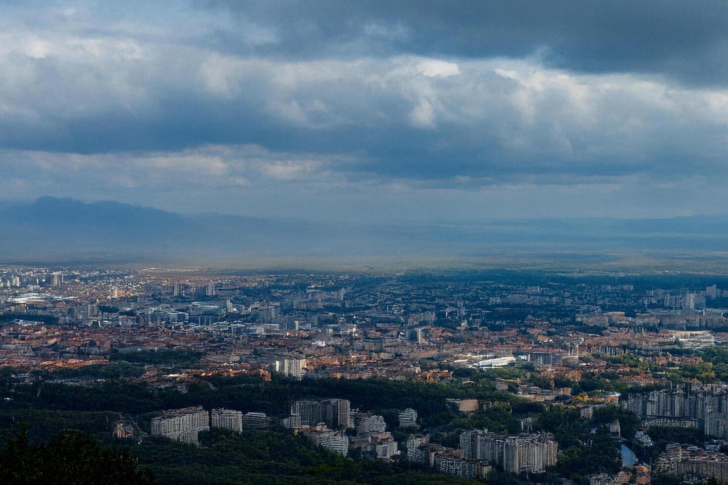 Cityscape panorama, overcast sky, mountain backdrop, travel brochure photo