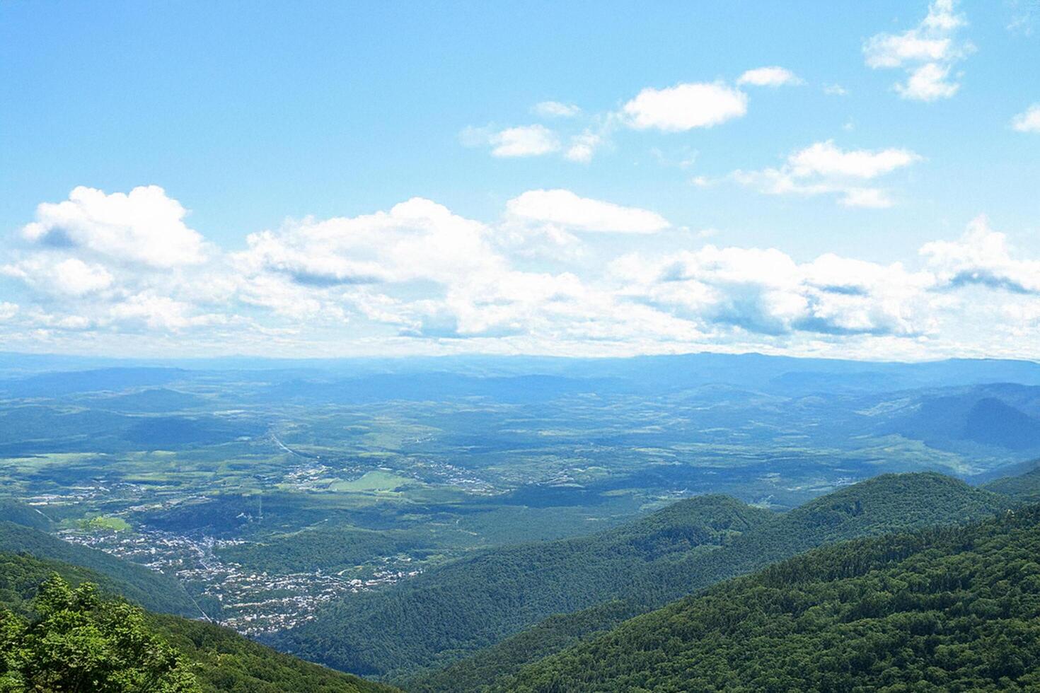 Mountaintop panoramic view valley, town, clouds photo