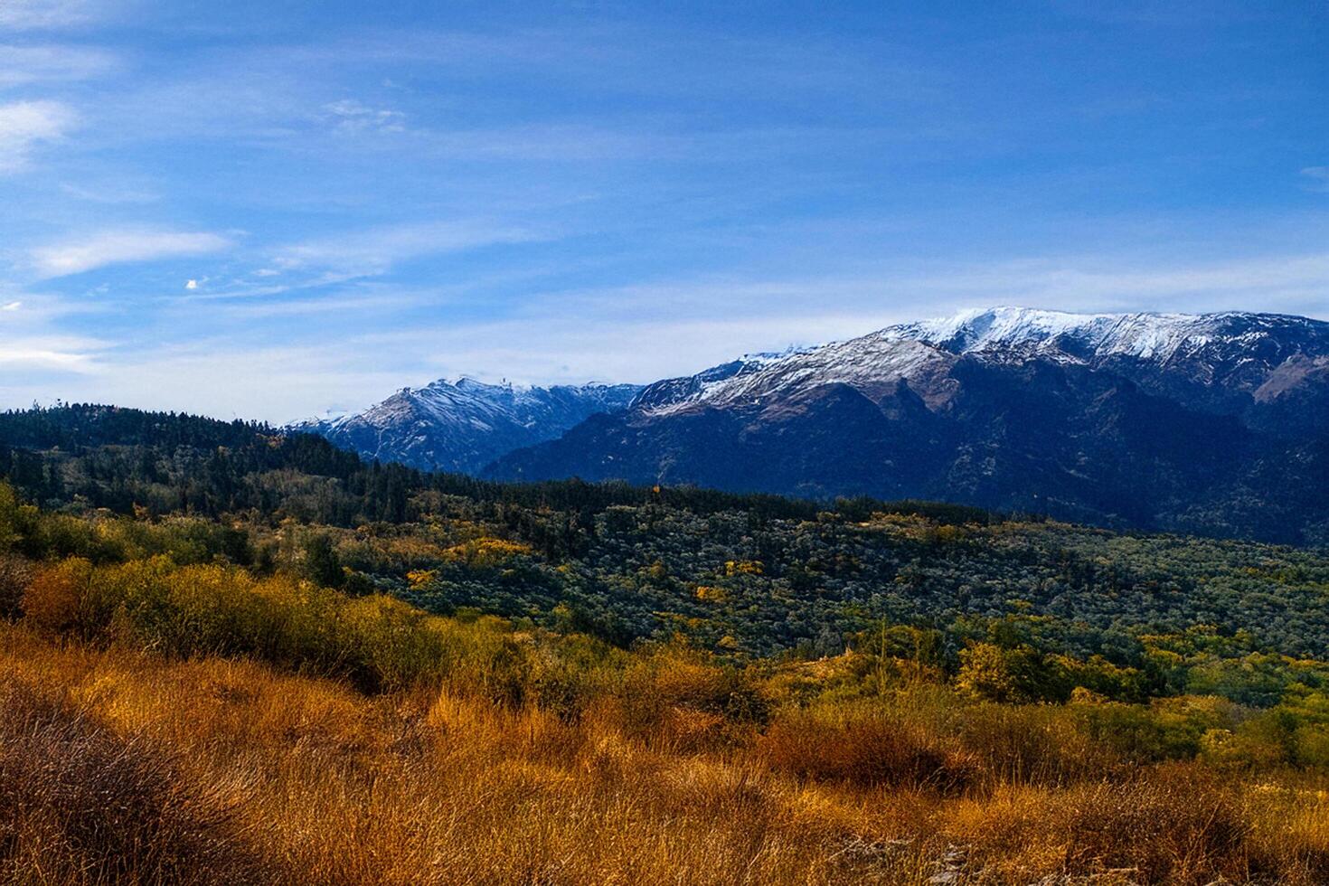 Autumnal mountain vista, snow-capped peaks, valley landscape, clear sky photo