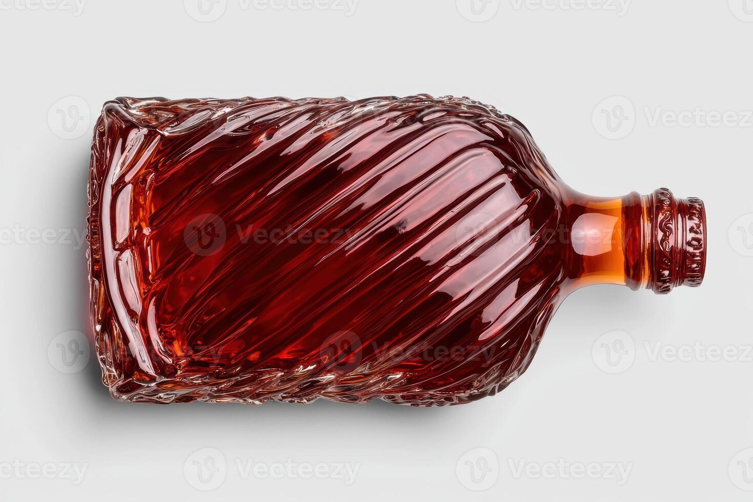 Top view of a bottle of dark amber liquid with a unique design photo