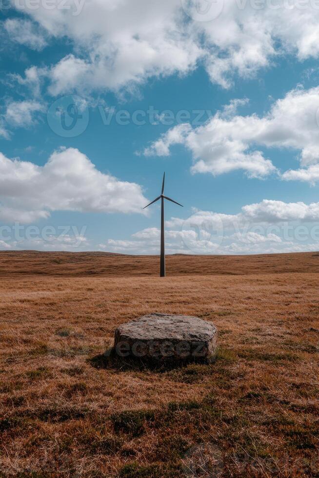 Single wind turbine in a vast field under a cloudy sky photo